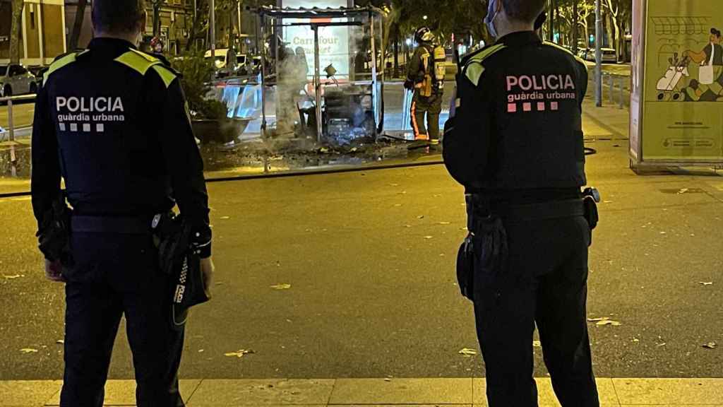 Agentes de la Guardia Urbana observan el puesto de castañas calcinado en la rambla Guipúscoa / A. FERNÁNDEZ - METRÓPOLI