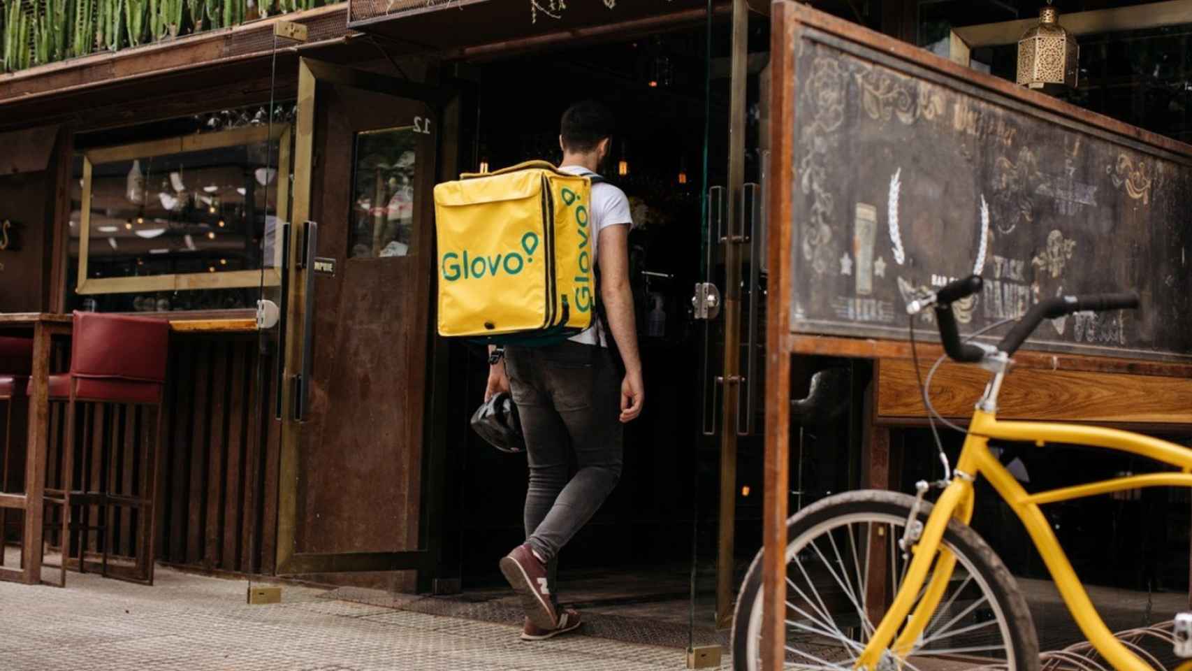 Un repartidor de Glovo entrando en un establecimiento