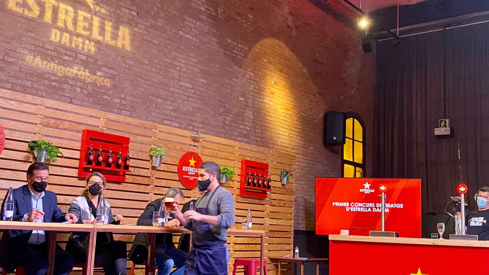 Un concursante entrega la cerveza al jurado en la Antigua Fábrica Estrella Damm / METRÓPOLI