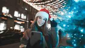 Una chica con un gorro de Navidad se hace fotos, en una imagen de archivo / DEPOSITPHOTOS