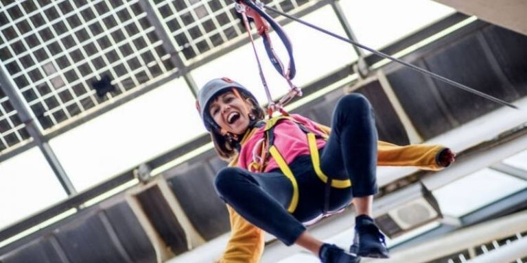 Una joven se lanza por una tirolina del Bosc Urbà / BOSC URBÀ 