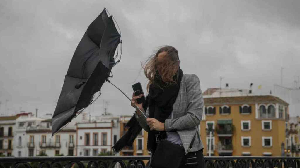 Una persona sujeta el paraguas ante las fuertes rachas de viento