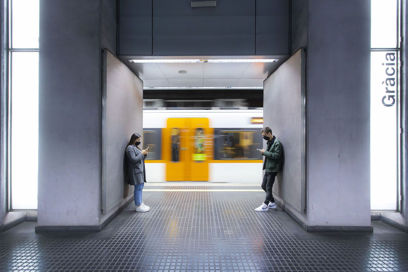 Dos personas esperan en el andén de la parada de Gràcia de Ferrocarrils de la Generalitat de Catalunya / FGC