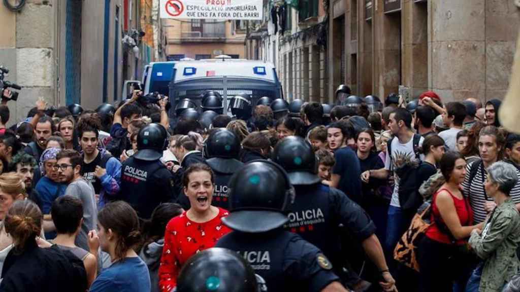 Mossos y activistas antidesahucios durante un desalojo en el barrio del Raval