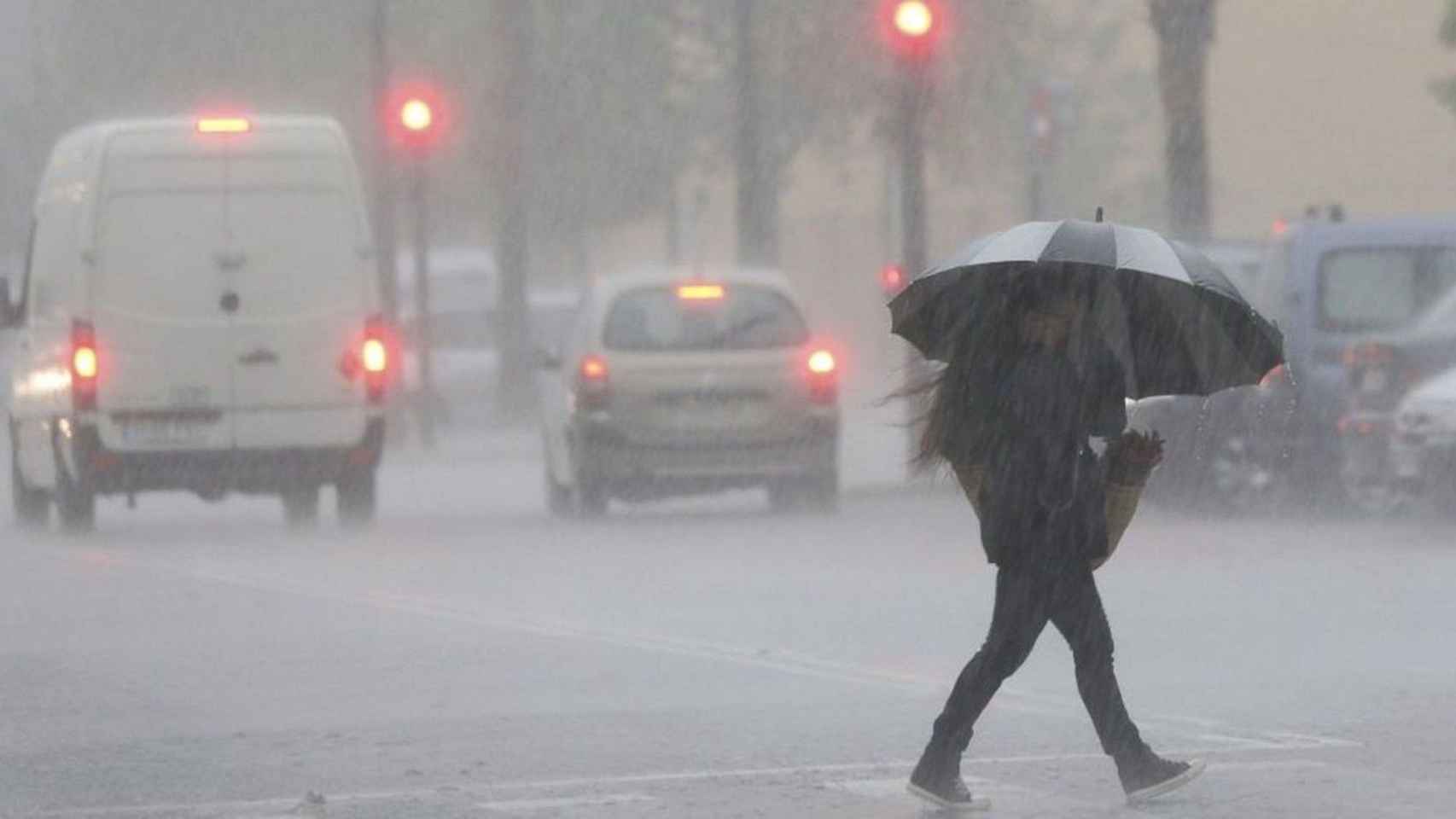 Una mujer se protege de la lluvia bajo un paraguas en Barcelona / EFE