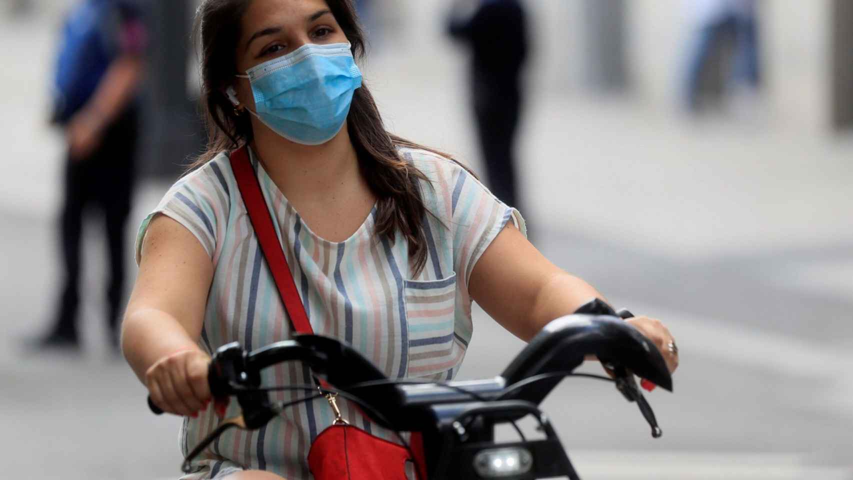 Una persona monta en bici cubierta con una mascarilla / EFE