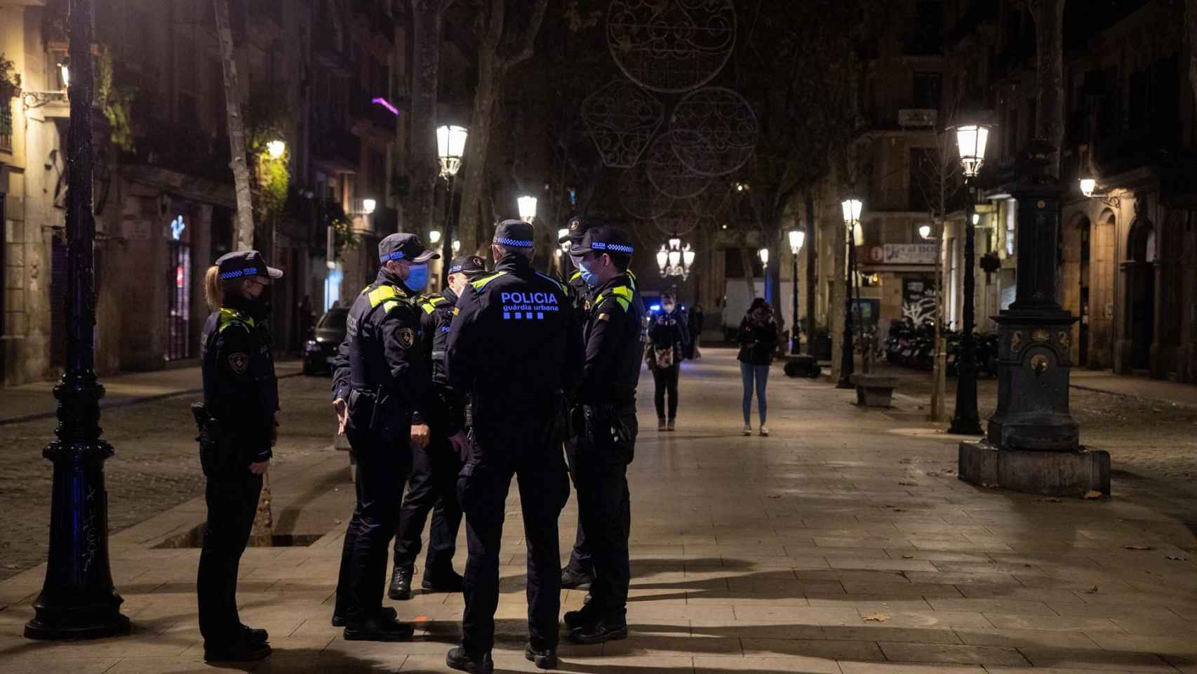 Agentes de la Guardia Urbana informando de la entrada en vigor del toque de queda en Nochebuena - Kike Rincon/Europa Press