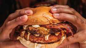 Un hombre comiendo una de las hamburguesas caseras más increíbles de Barcelona / CHIVUOS