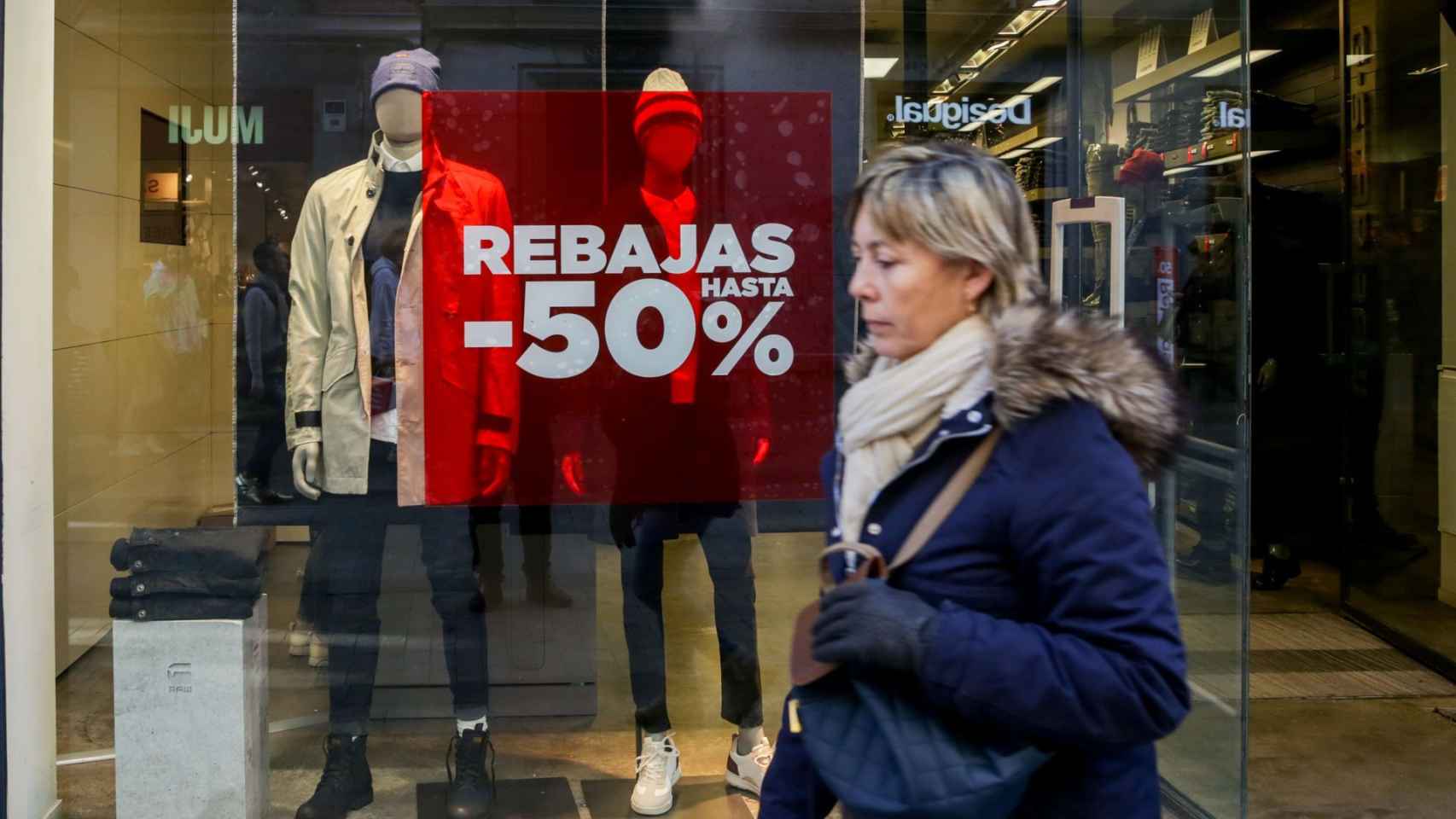 Una mujer pasea frente a un cartel de rebajas en una imagen de archivo / EUROPA PRESS