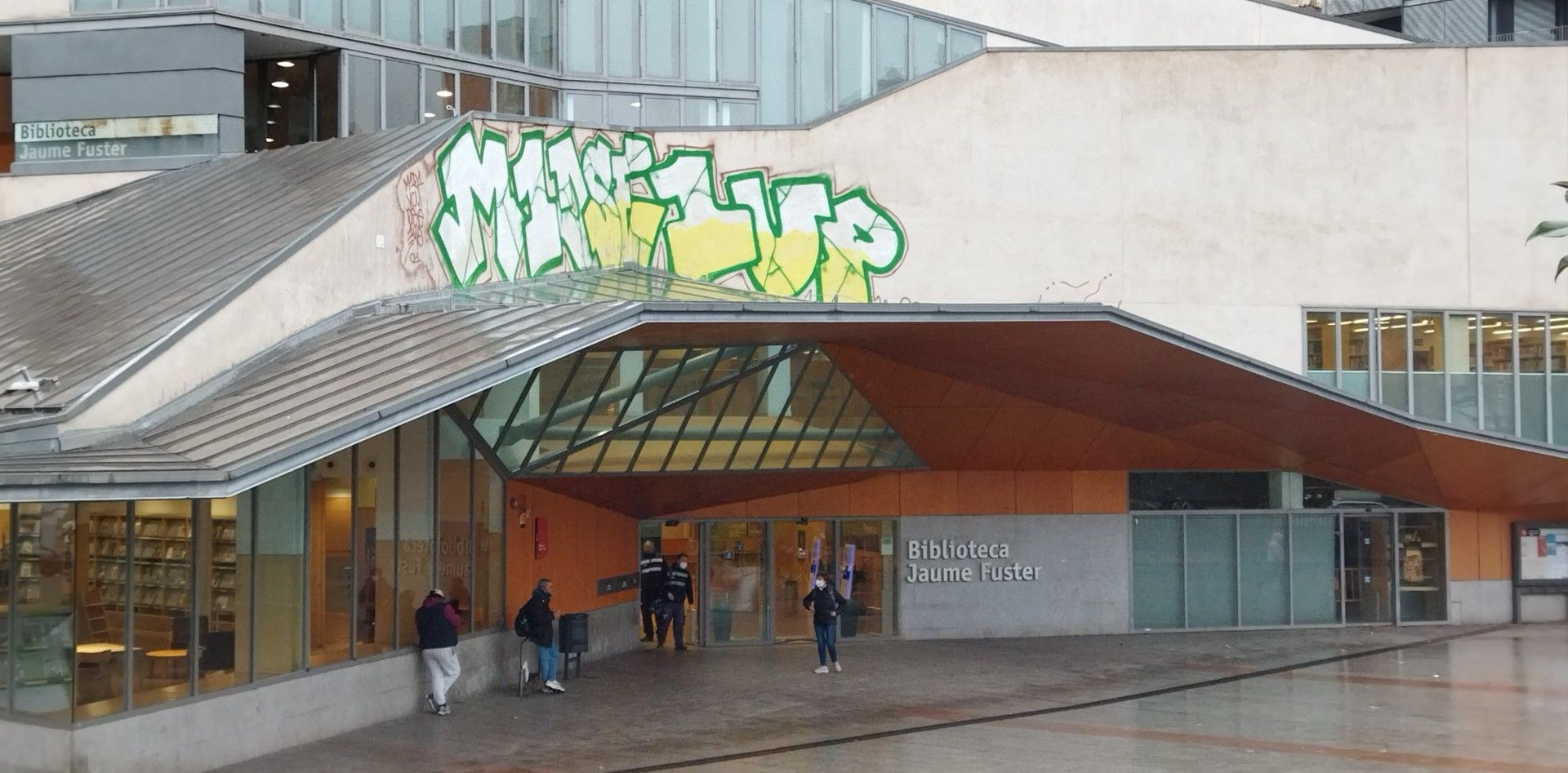 Un gran grafiti preside la fachada principal de la biblioteca Jaume Fuster de Gràcia / METRÓPOLI - JORDI SUBIRANA