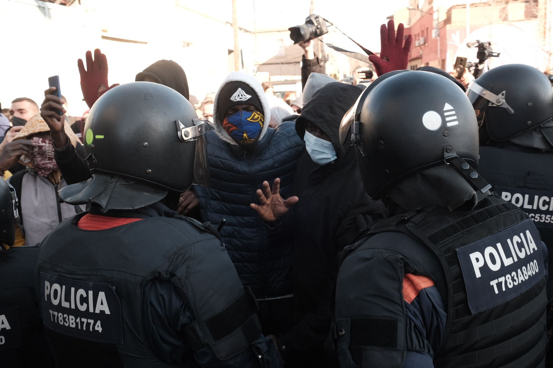 Los okupas de la nave de Badalona levantando las manos ante la policía / PABLO MIRANZO - MA