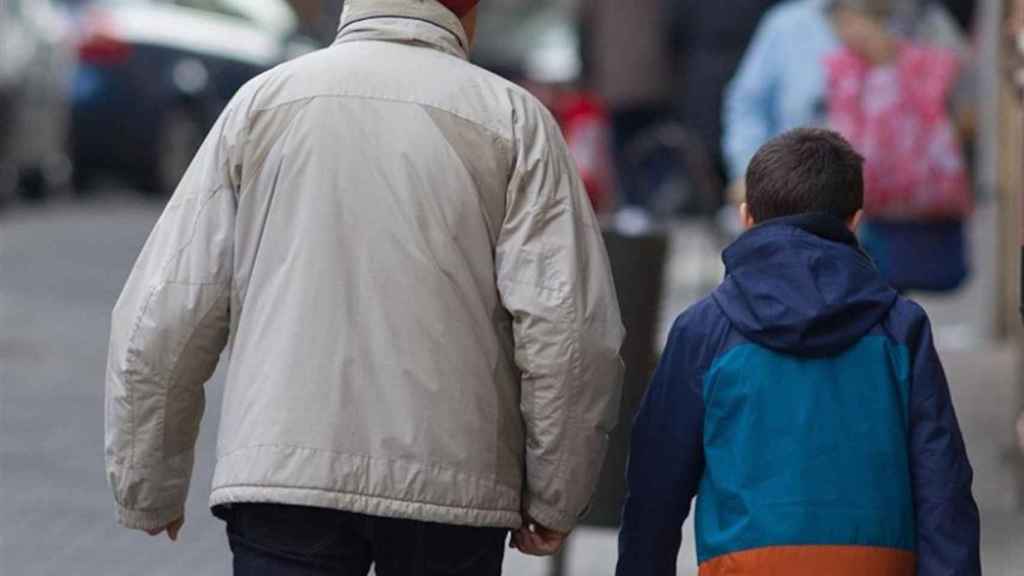 Un hombre y un niño, abrigados para combatir el frío