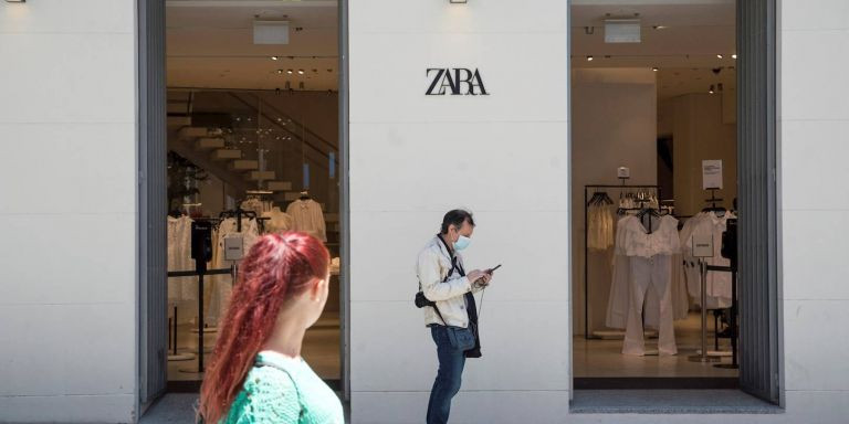 Dos personas paseando por una calle de Barcelona y cubiertos con mascarilla / EFE