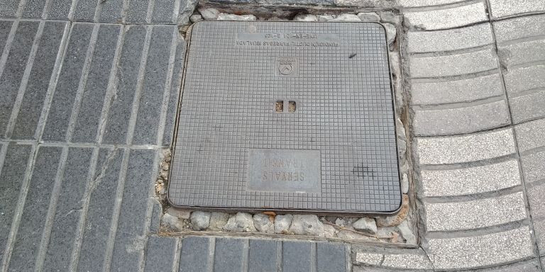 Una tapa de servicios en mal estado en la Rambla / AMICS DE LA RAMBLA 