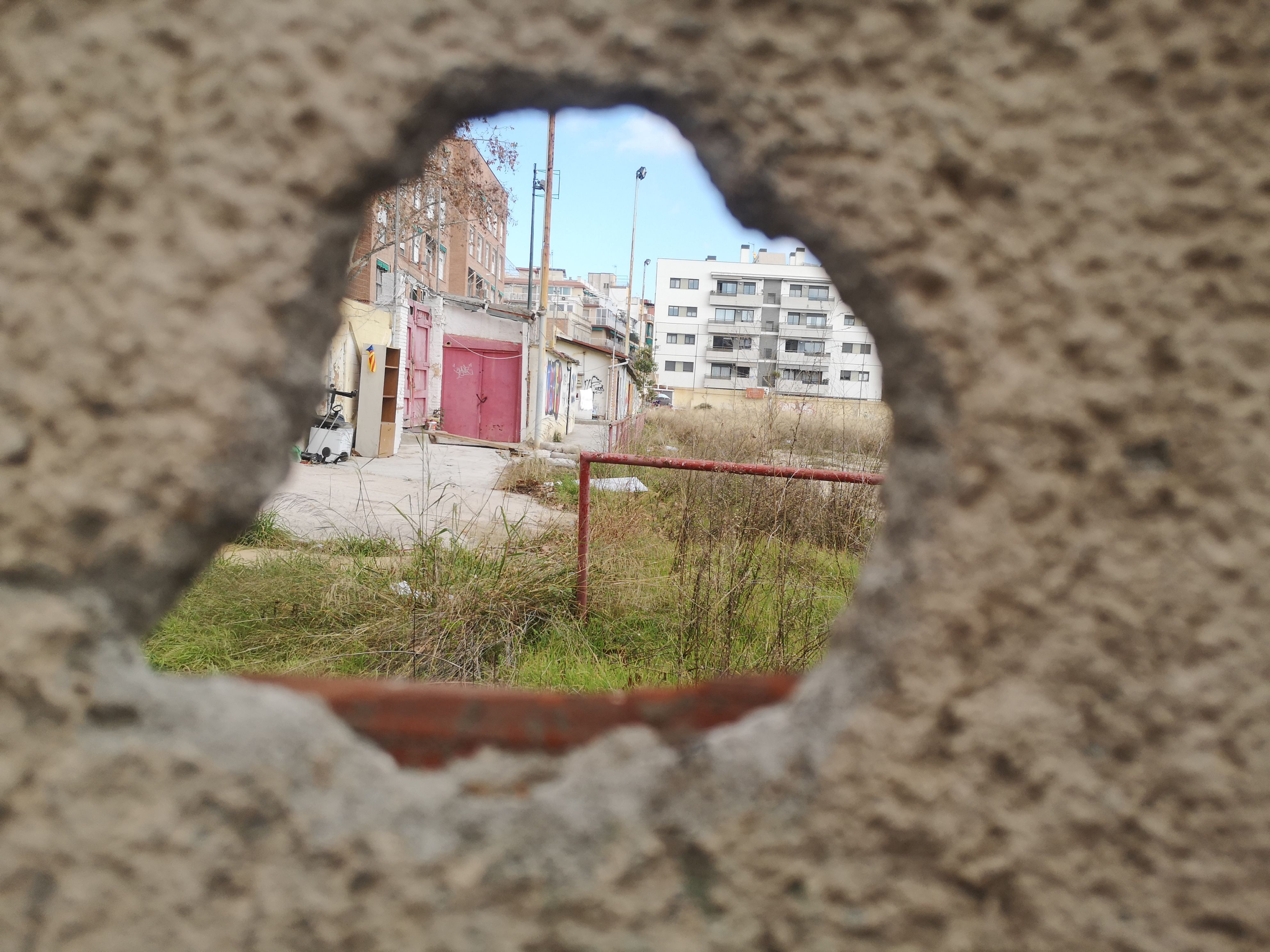 Imagen del antiguo campo de fútbol de la Damm a través de un agujero / GUILLEM ANDRÉS