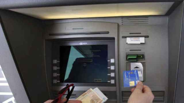 Un cliente saca dinero de un cajero automático en el banco / EFE