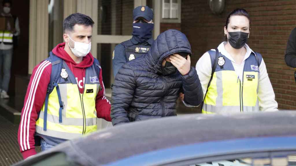 Dos agentes de la Policía Nacional se llevan detenido a un empleado del Ayuntamiento de Cornellà / EFE