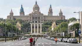 Ciclistas pedaleando por el carril bici de la avenida de la Reina Maria Cristina con el MNAC de fondo / AYUNTAMIENTO DE BARCELONA