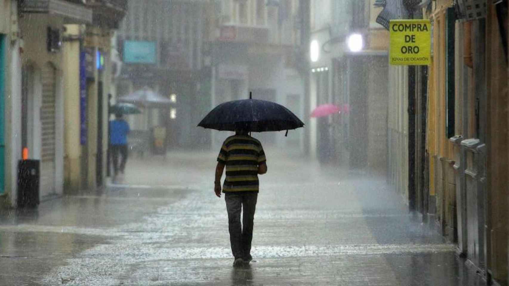 Un hombre con un paraguas bajo una fuerte tormenta de primavera / EFE