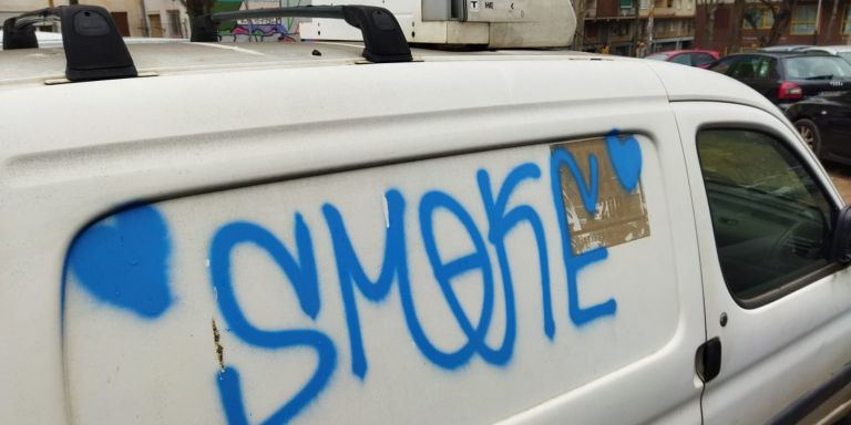 Un grafiti en un coche en el aparcamiento del Baix Guinardó / METRÓPOLI