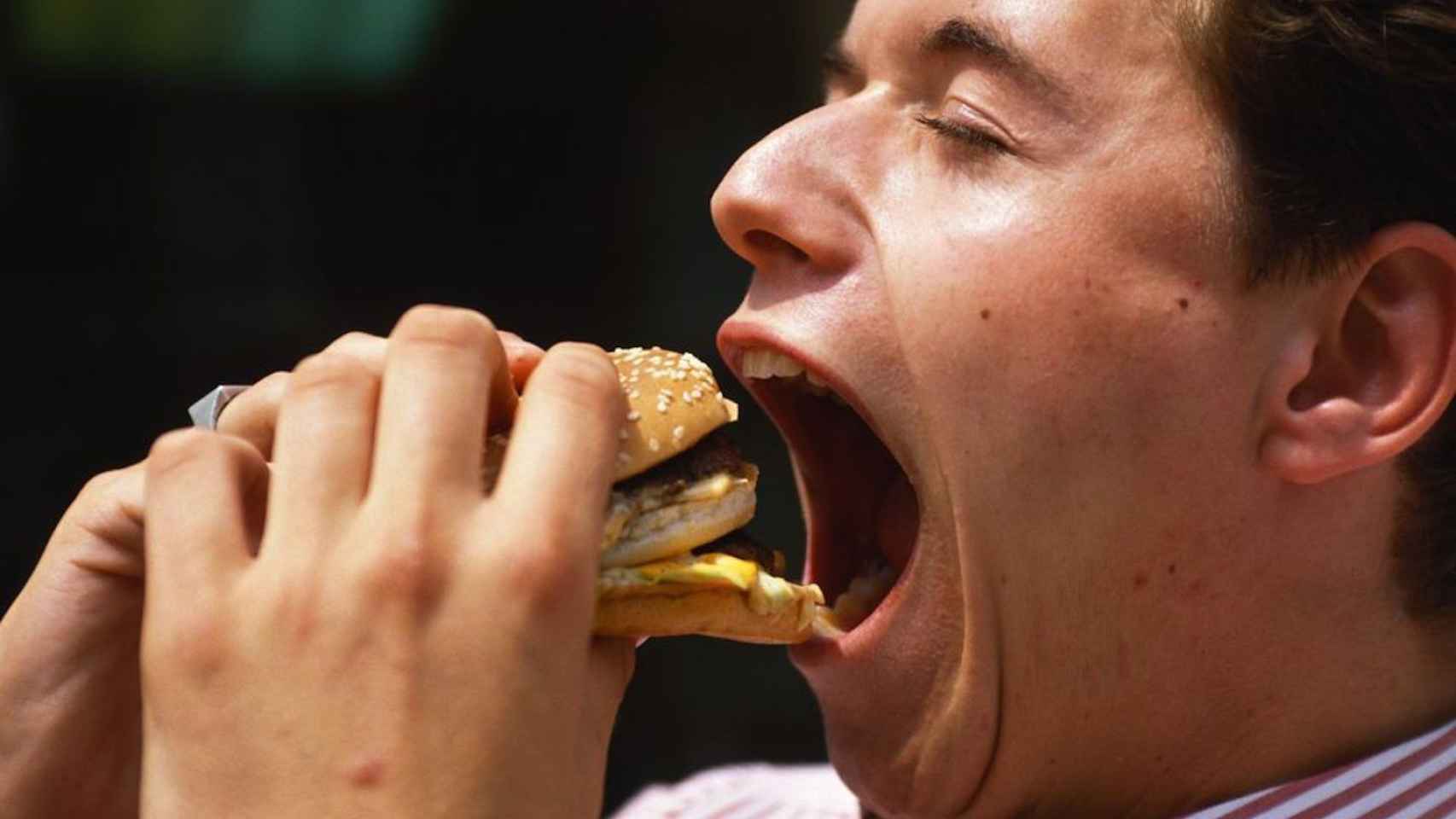 Un hombre comiéndose una hamburguesa en una imagen de archivo / REDES SOCIALES