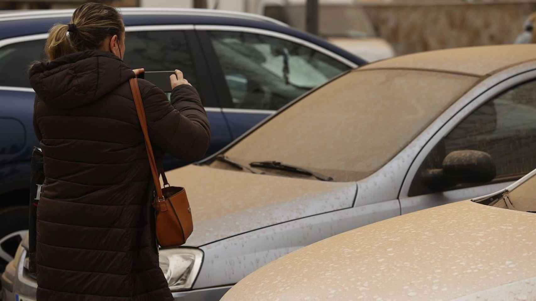 Una mujer fotografía su coche tras la lluvia de barro de la pasada semana / EFE