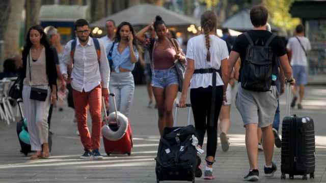 Turistas con maletas en La Rambla de Barcelona