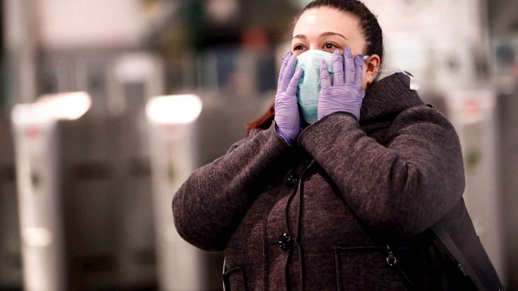 Una mujer se protege del covid con una mascarilla / EFE