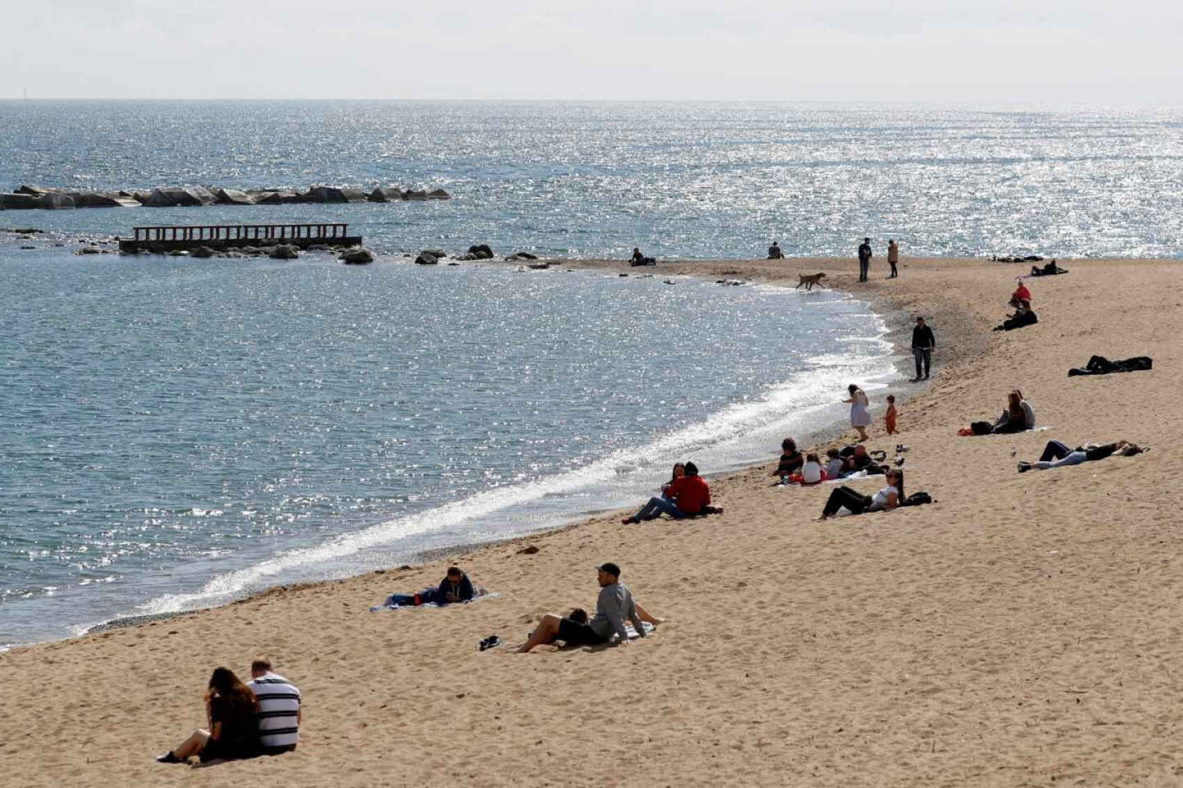 Varias personas toman el sol en la playa de Barcelona / EFE