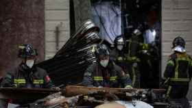 Bomberos trabajan en el exterior del edificio incendiado este martes en el Eixample / EUROPA PRESS