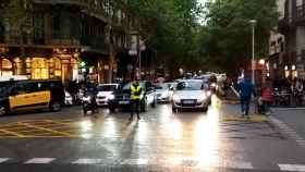 Un auxiliar delante de coches en la confluencia de rambla de Catalunya con València, en el centro de Barcelona / METRÓPOLI