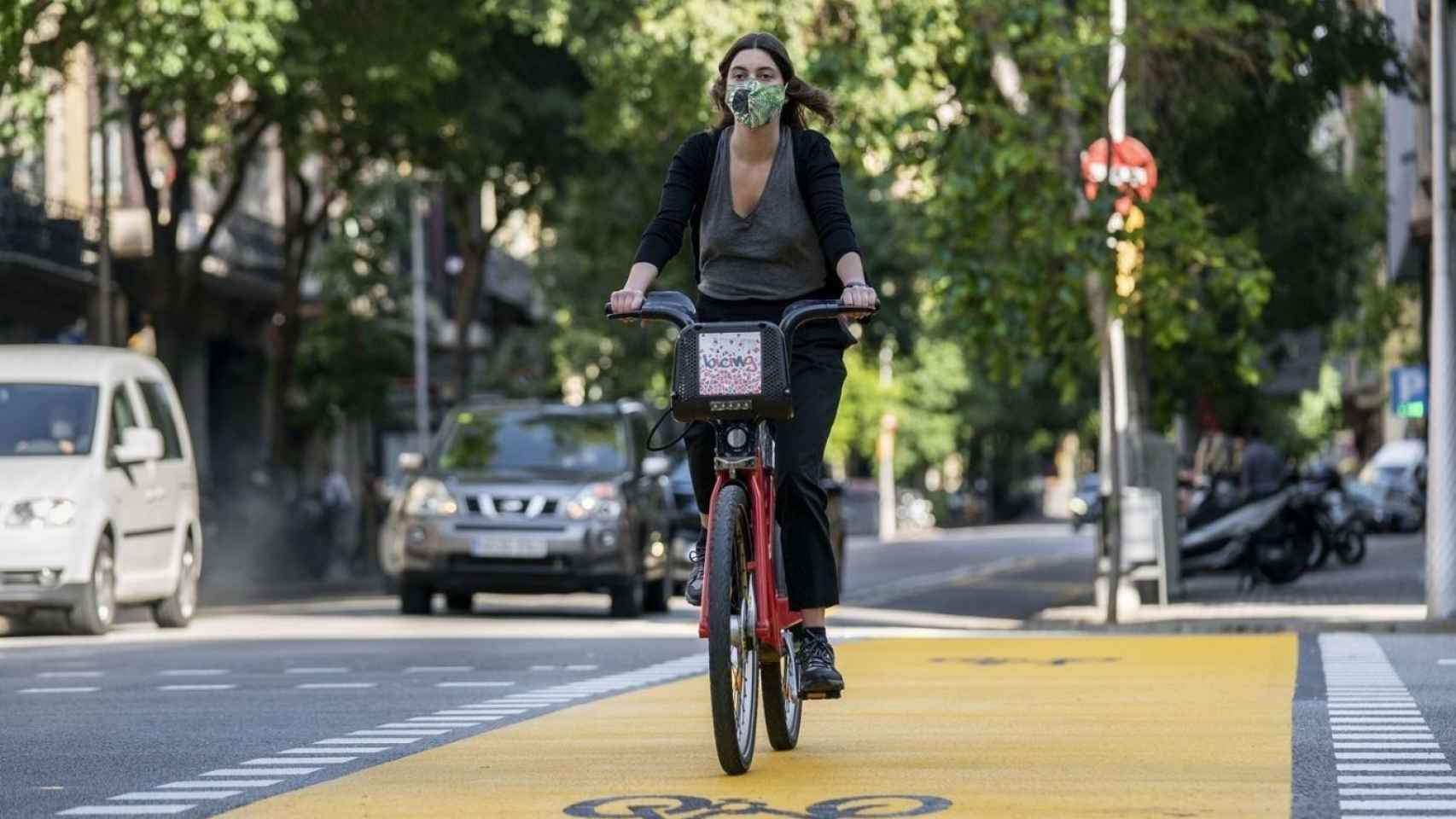 Una ciclista con mascarilla en Bicing por la calle de Pau Claris / AYUNTAMIENTO DE BARCELONA