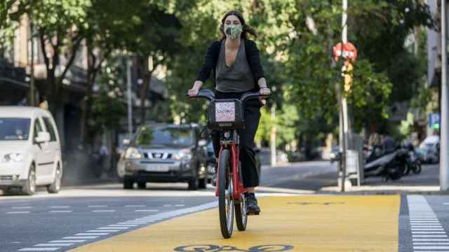 Una ciclista con mascarilla en Bicing por la calle de Pau Claris / AYUNTAMIENTO DE BARCELONA