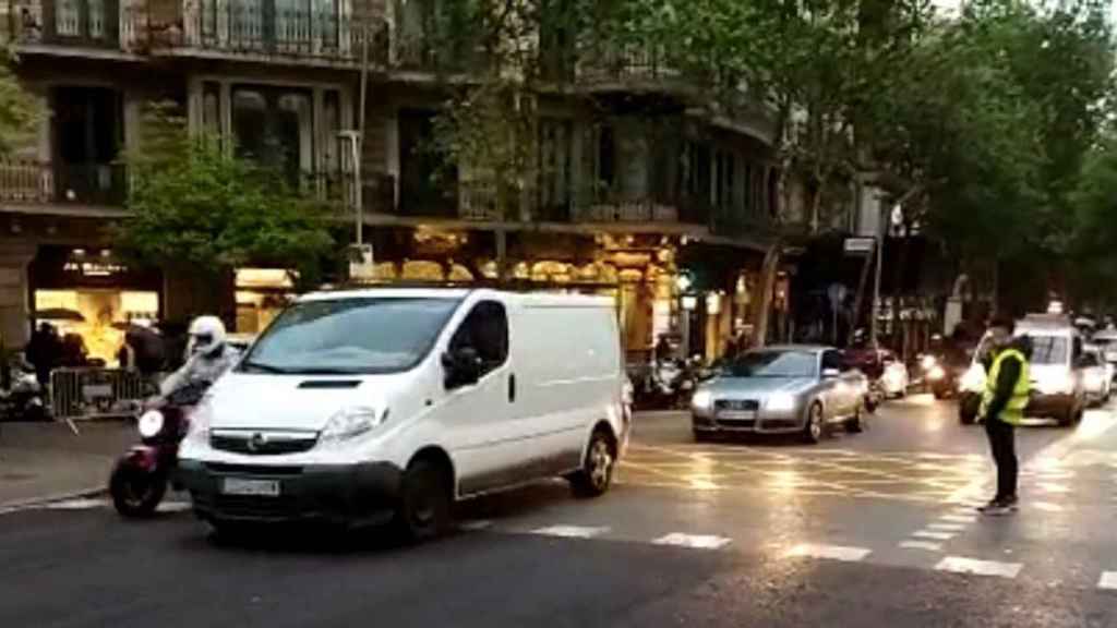 Un civil, con chaleco, junto al tráfico el sábado, día de Sant Jordi, en el centro de Barcelona / METRÓPOLI