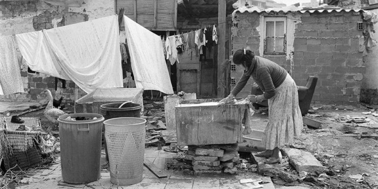 Una mujer lava la ropa en un fregadero en medio de la calle en 1981 / ESTEVE LUCERÓN