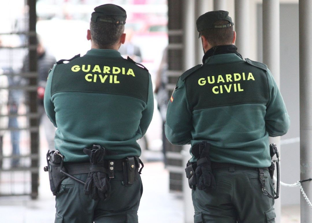 Dos agentes de la Guardia Civil de espalda