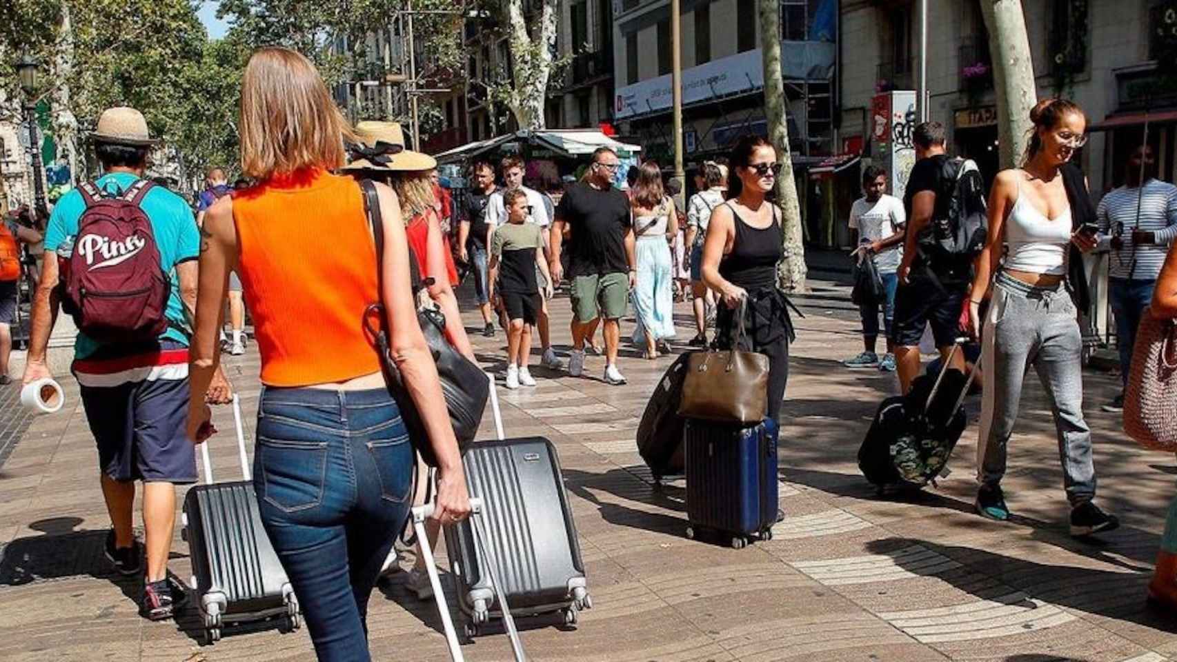 Turistas con maletas en la Rambla de Barcelona