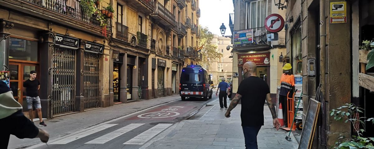 Un furgón policial circula en la calle de l'Hospital, en el Raval / GUILLEM ANDRÉS