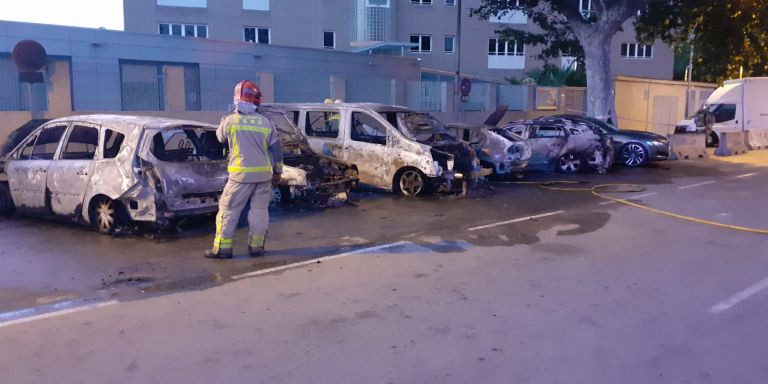 Bombero apagando el incendio que ha calcinado cinco coches en Sant Adrià de Besòs / CEDIDA