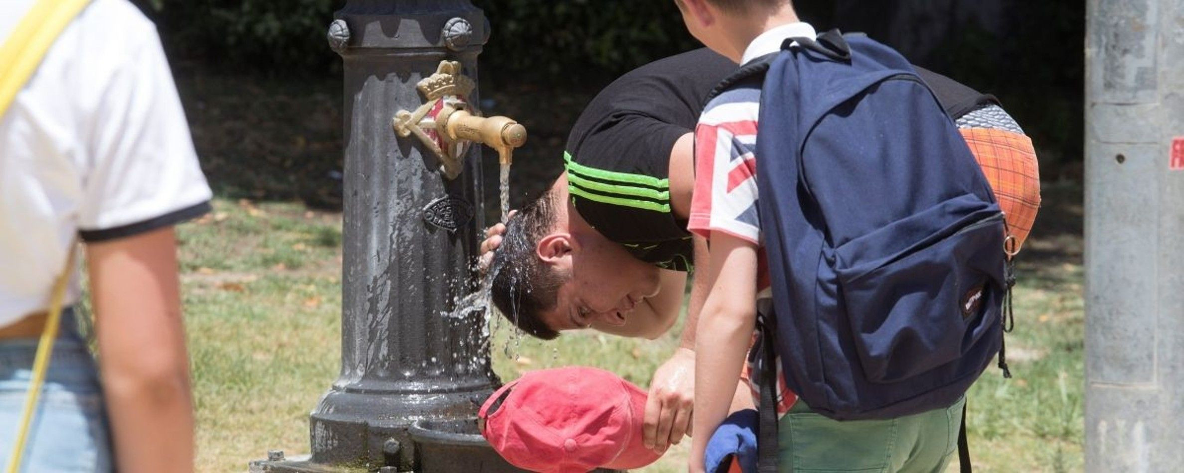 Un joven se moja la cabeza en Barcelona durante una ola de calor / EFE