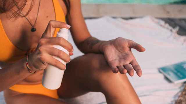 Una joven se aplica crema en la playa: los protectores solares son necesarios en verano / PX