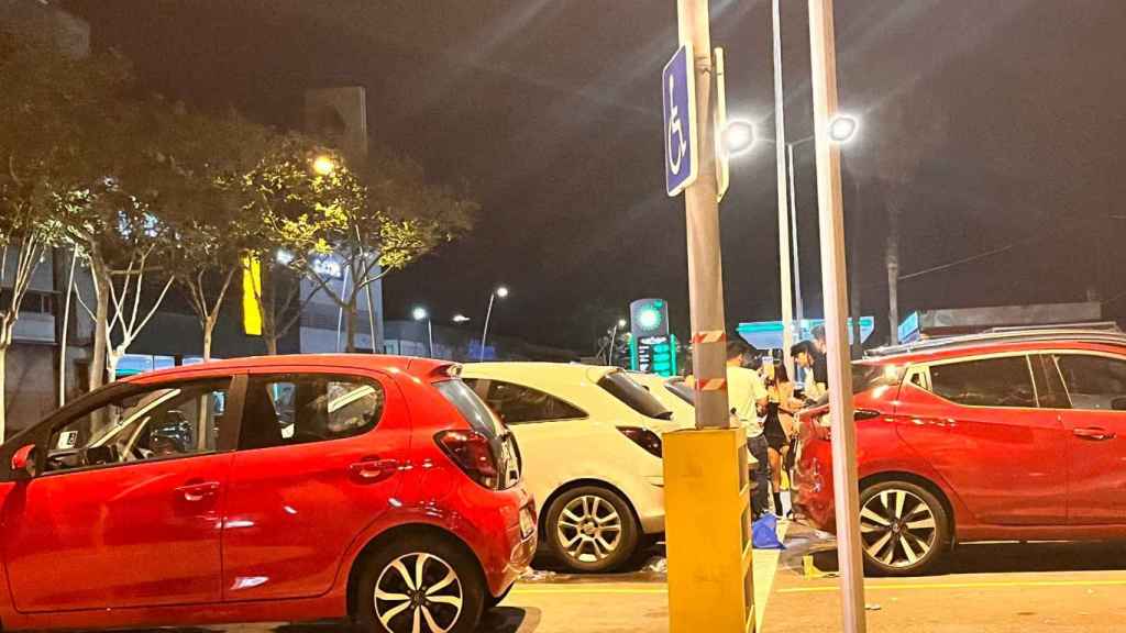 Jóvenes entre los coches haciendo botellón / ÁNGELA VÁZQUEZ