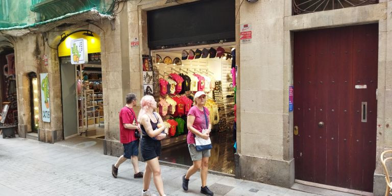 Dos turistas junto a una tienda de 'souvenirs' / METRÓPOLI - JORDI SUBIRANA