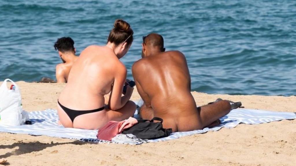 Dos personas practicando nudismo en la playa de la Barceloneta