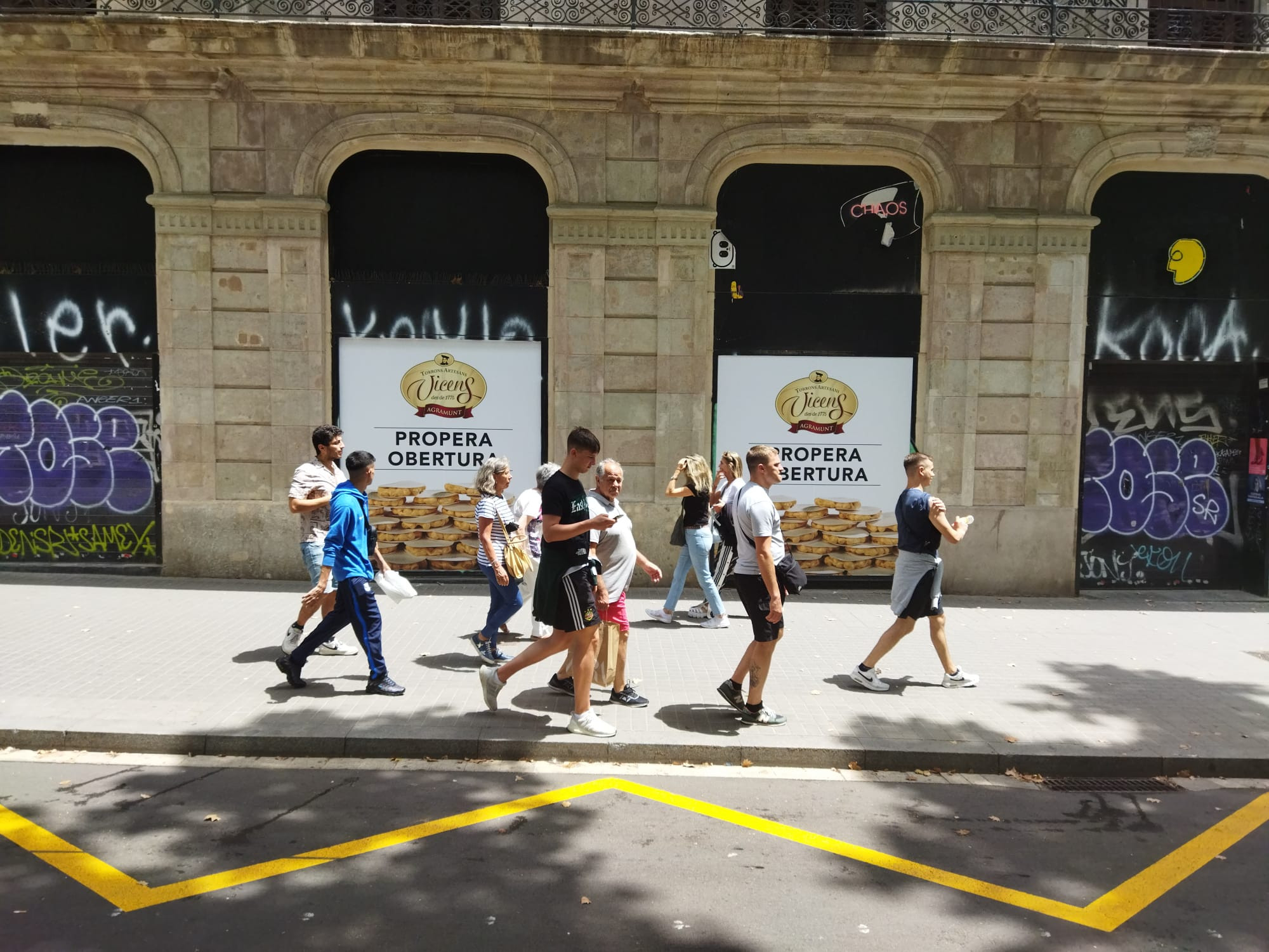 Un grupo de turistas pasa delante de la futura tienda de Torrons Vicens en la Rambla / METRÓPOLI - JORDI SUBIRANA