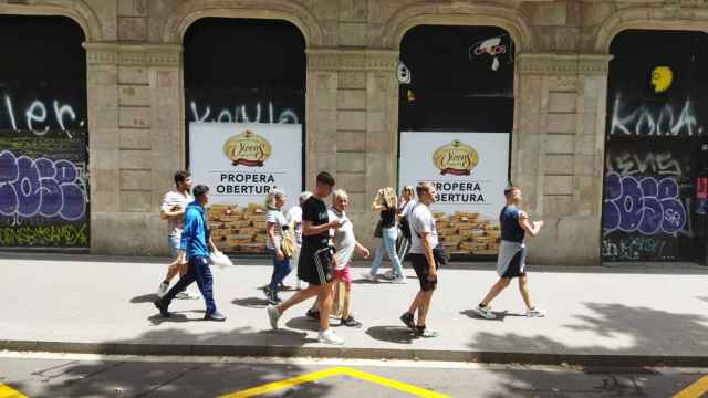 Un grupo de turistas pasa delante de Torrons Vicens en la Rambla antes de abrir / METRÓPOLI - JORDI SUBIRANA