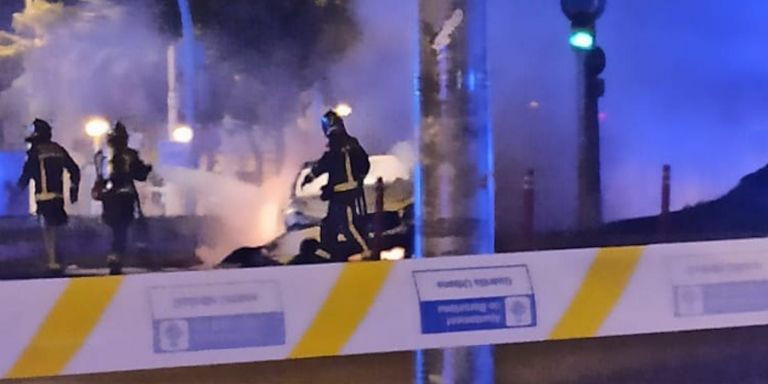 Bomberos apagando el fuego provocado por el coche tras colisionar contra la catenaria del tranvía / METRÓPOLI