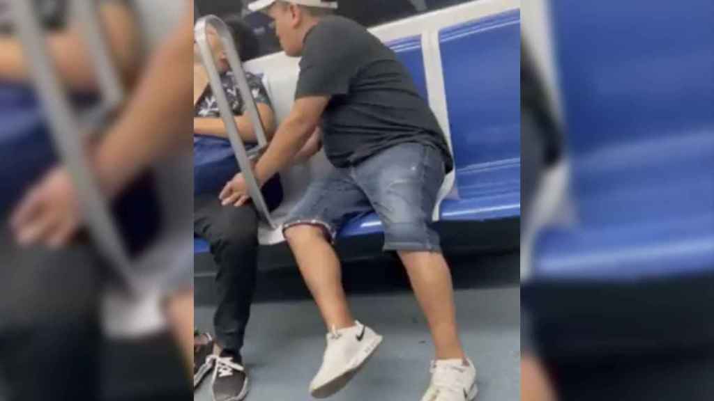 Captura de pantalla del momento del vídeo en el que el carterista roba a un hombre dormido en el metro de Barcelona / TWITTER