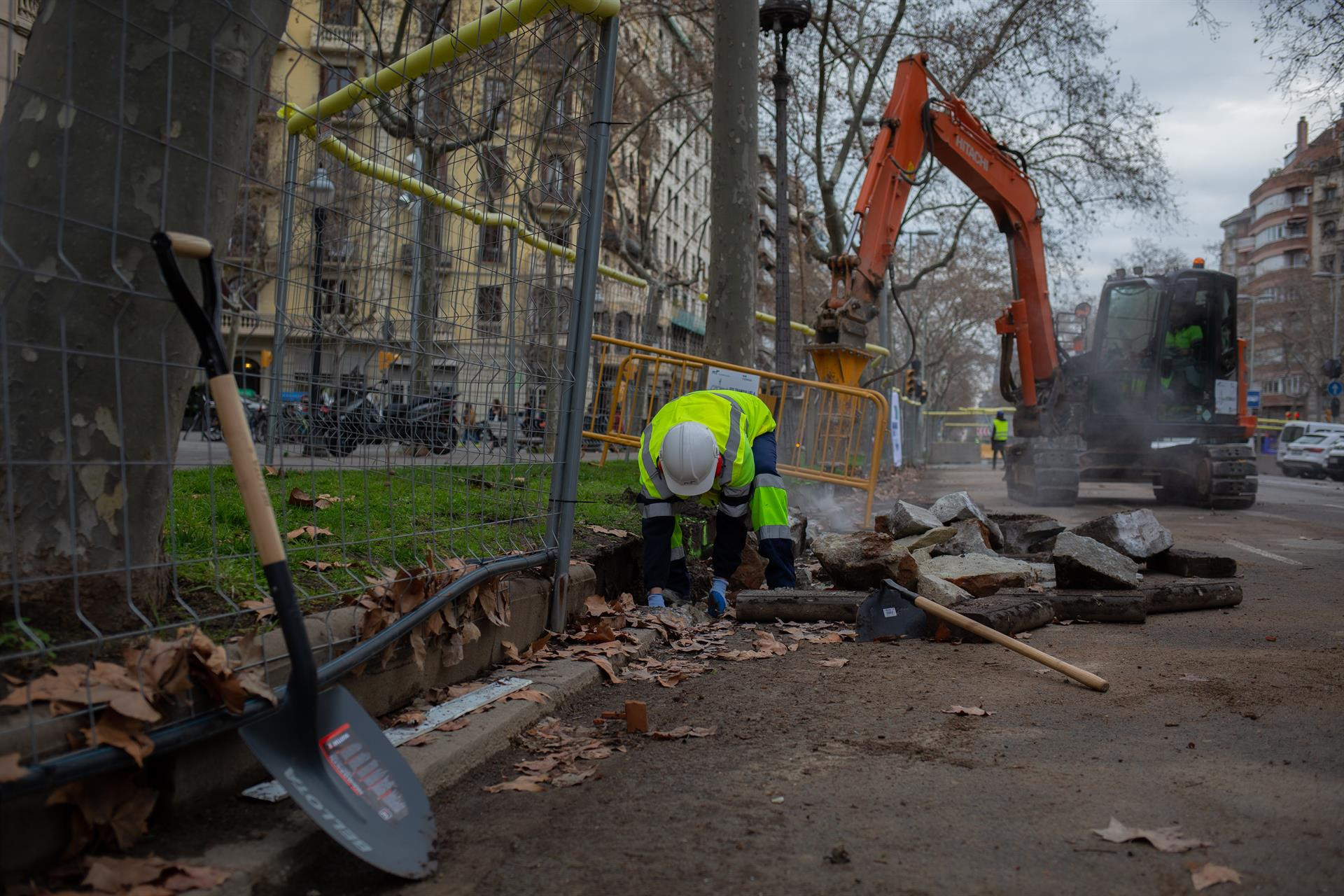 n obrero y una máquina excavadora trabajan en las obras para unir el tranvía por la Diagonal de Barcelona / EUROPA PRESS