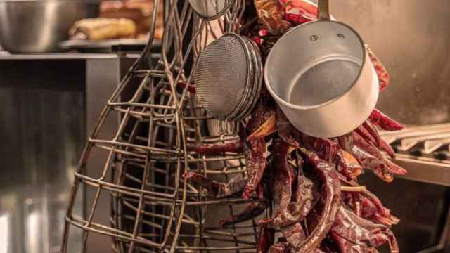 Una ristra de pimientos y utensilios de cocina en el restaurante Molino de Pez / MOLINO DE PEZ